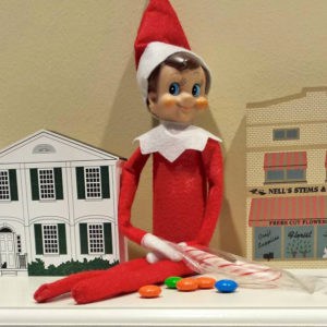 elf on the shelf with gingerbread house candy 