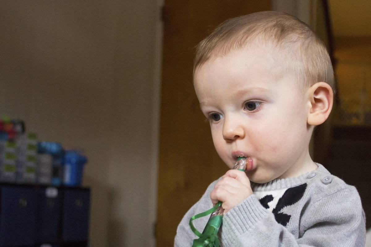 toddler blowing green horn 