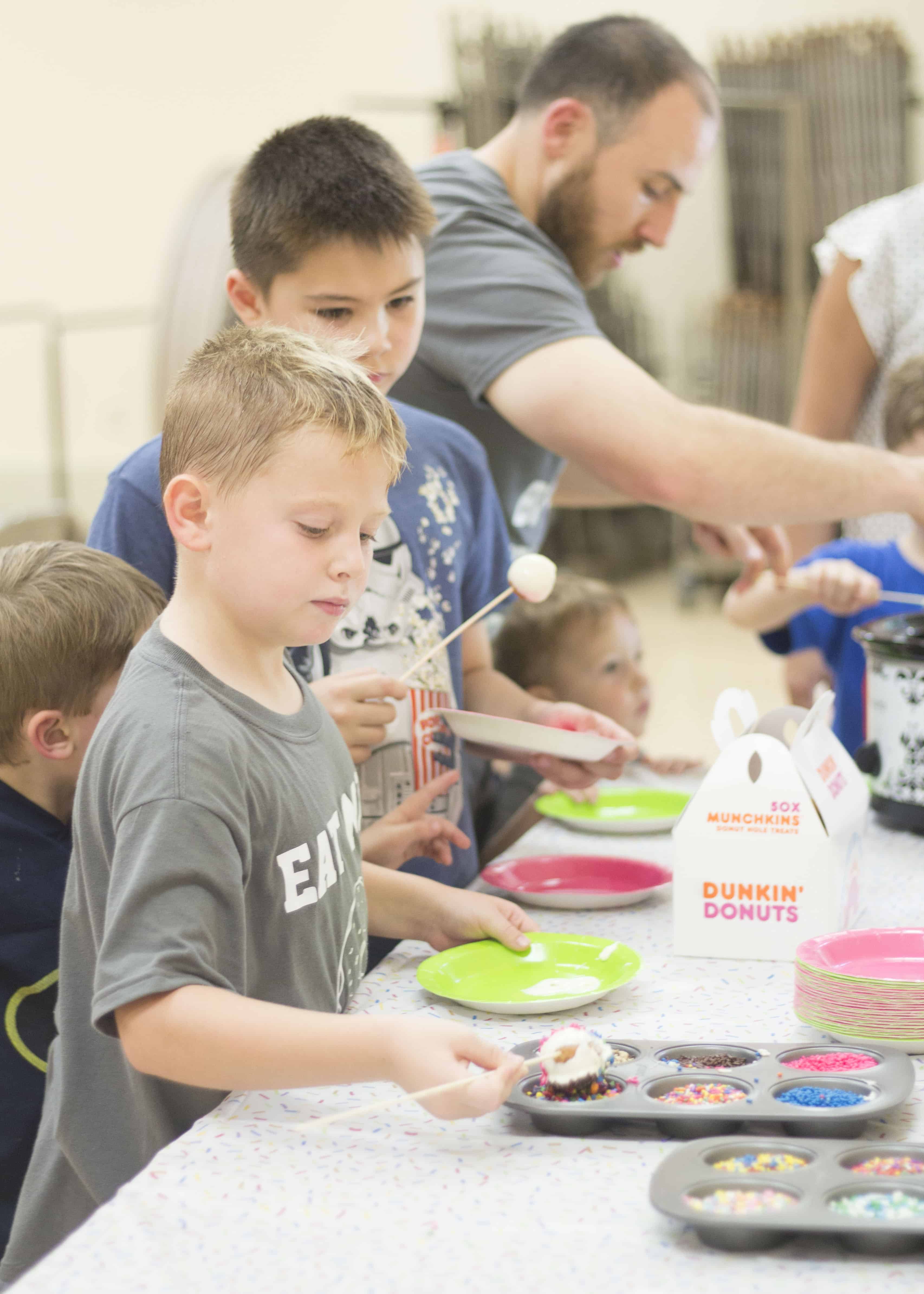 BOY ADDING SPRINKLES TO DONUT HOLE 