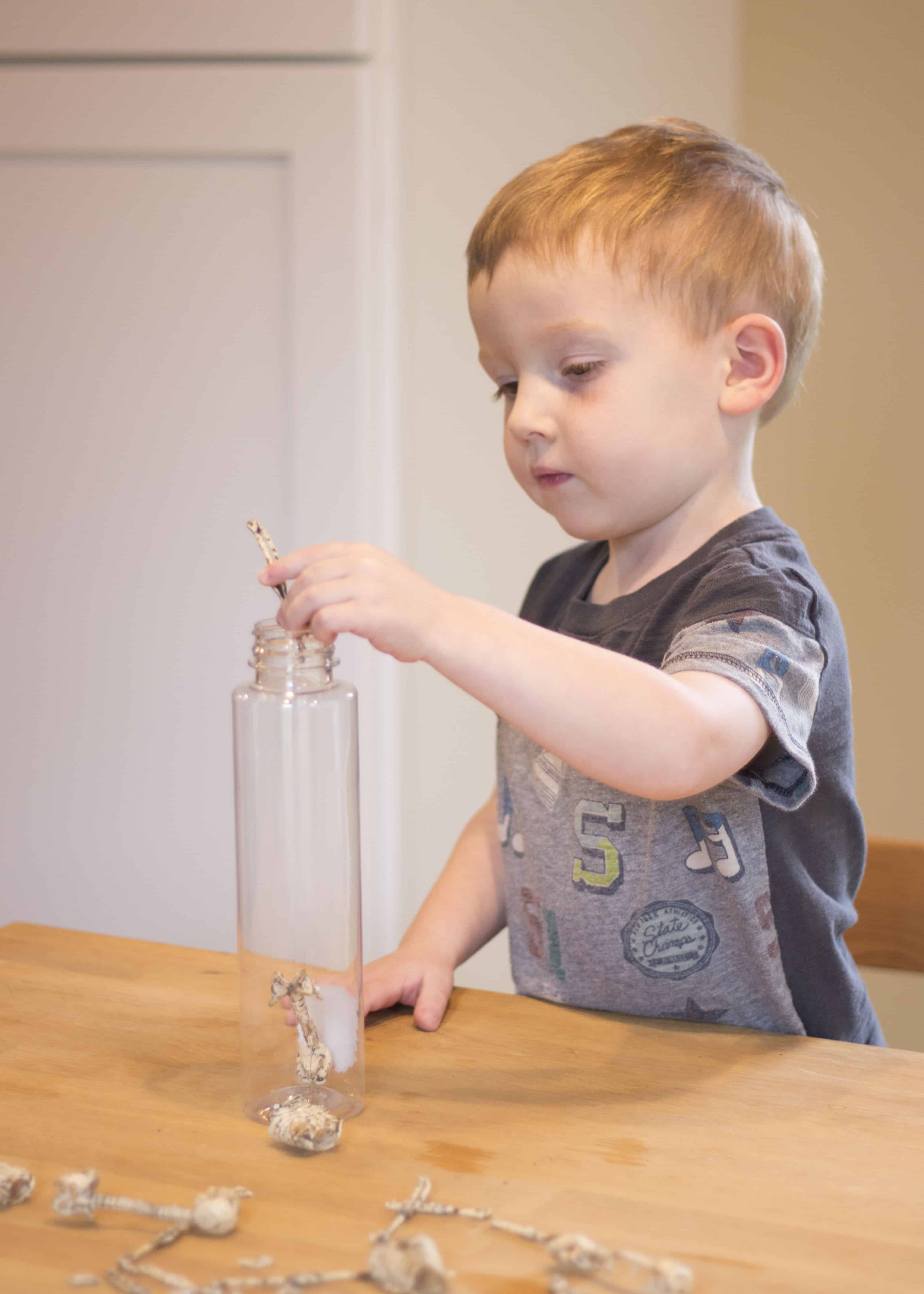 BOY PUTTING BONES IN BOTTLE