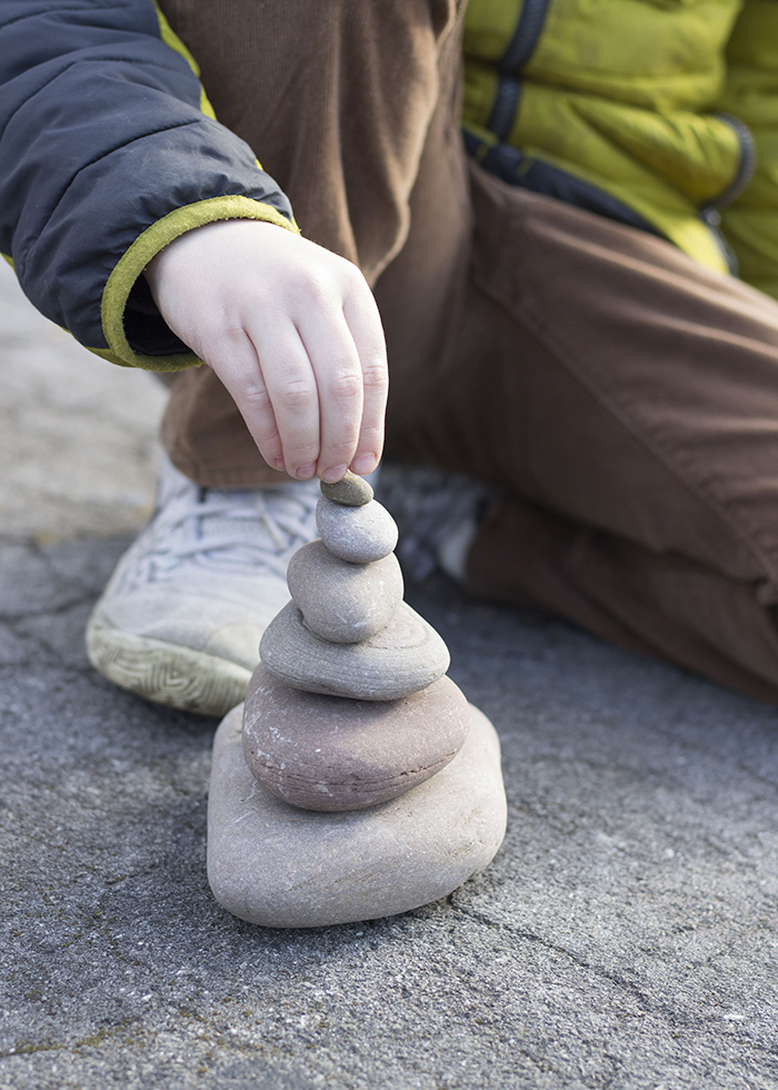 BOY STACKING ROCKS