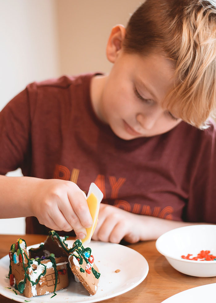 BOY DECORATING GINGERBREAD HOUSE